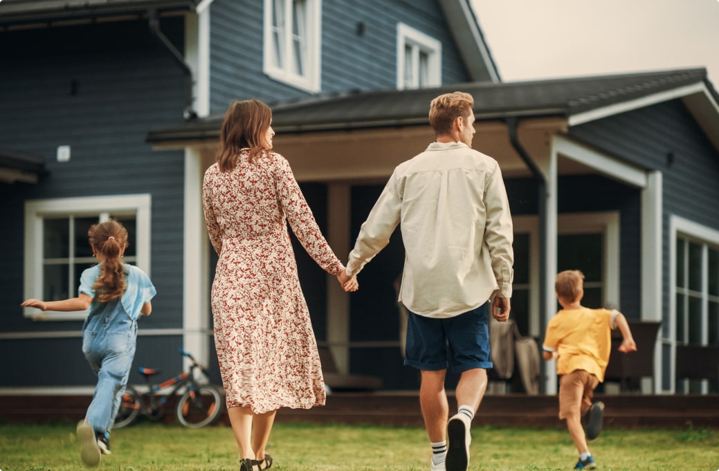 family of four walking towards a house